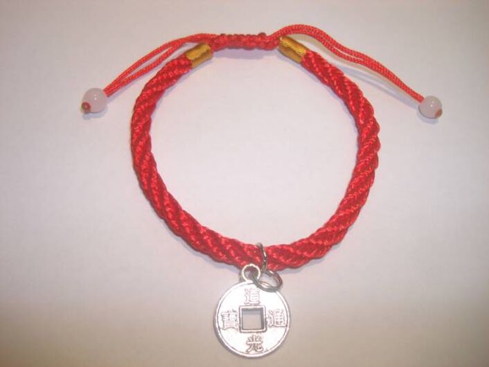 Bracelet with red thread with a rare coin to attract good luck